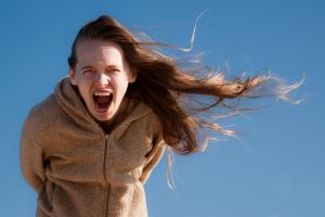girl screaming with her hair blown sideways by the wind