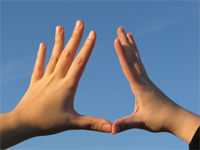 photo of hands against the sky with fingers spread